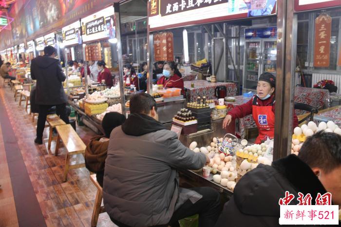 游客们坐在摊前品尝烤蛋。　潘琦 摄